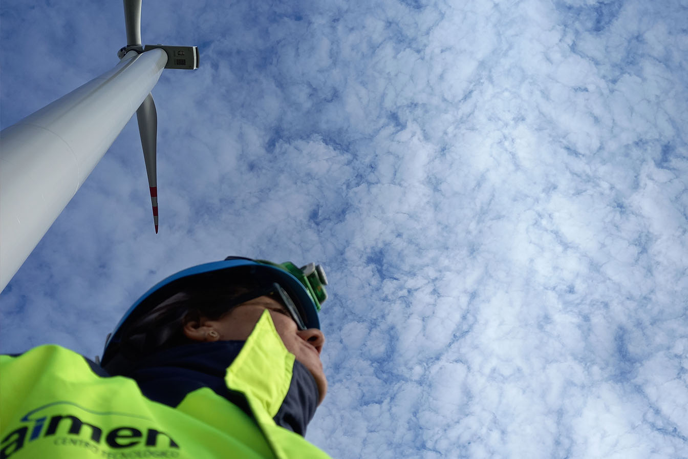 Operario junto a un molino eólico